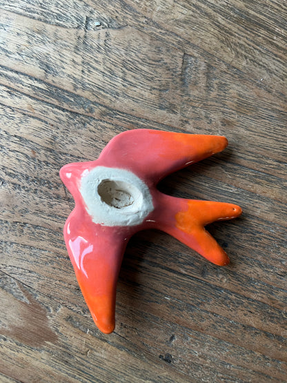 Zwaluw voor aan de muur roze oranje